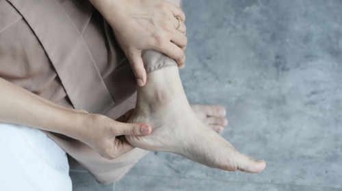 Woman rubbing ankle due to arthritis pain