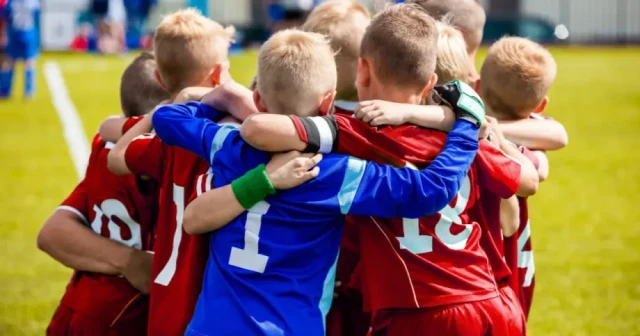 boys soccer team hugging after game